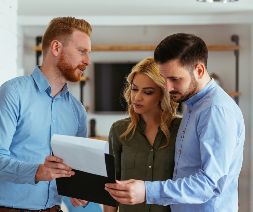 Three people reviewing health insurance documents