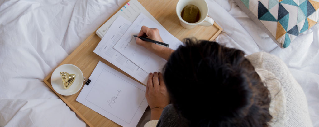 woman doing work in bed