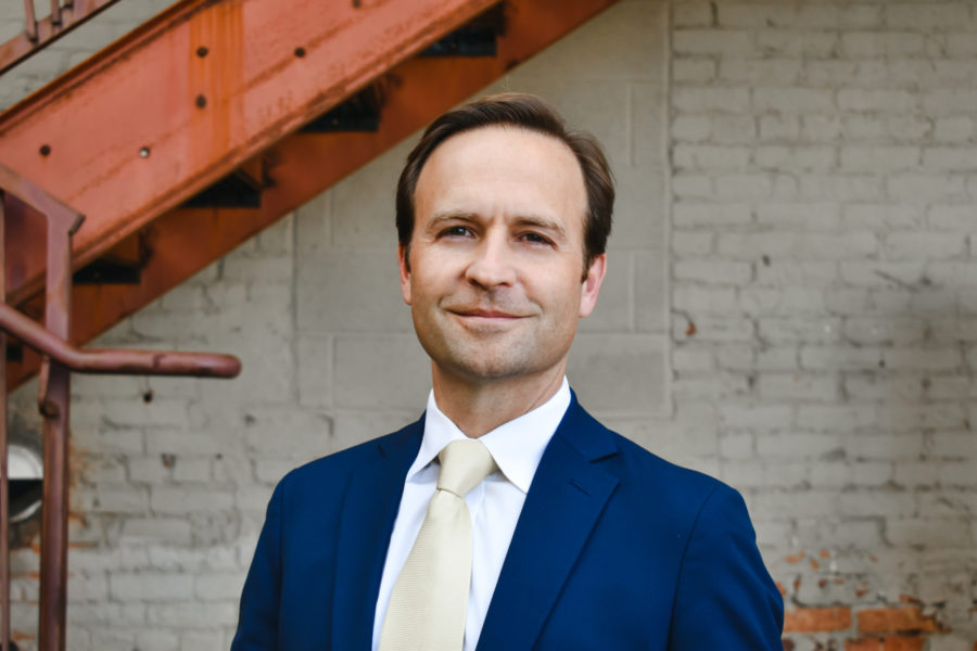 A man named Brian Calley poses in front of a building in Lansing