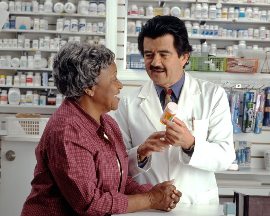 pharmacist talking to patient in pharmacy store