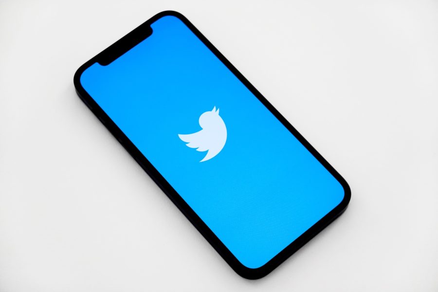 phone on desk with twitter app loading on screen
