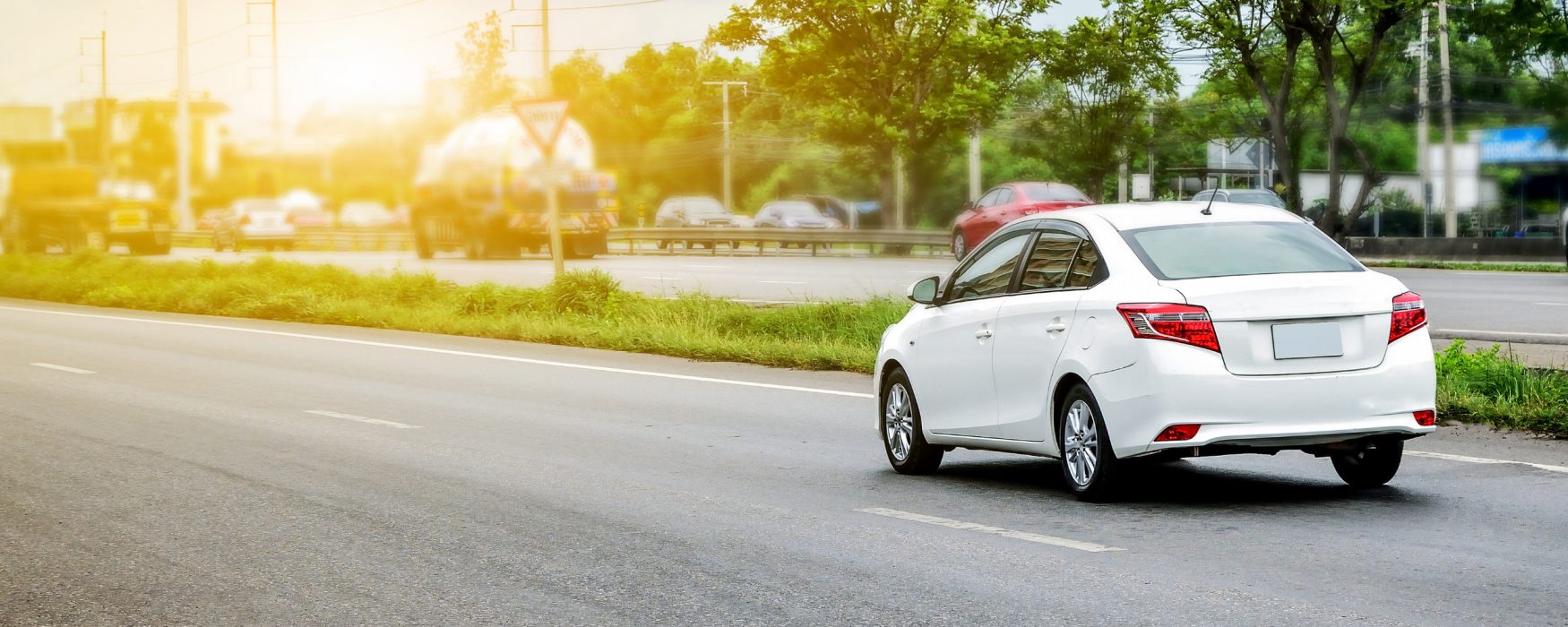 White car driving down a road