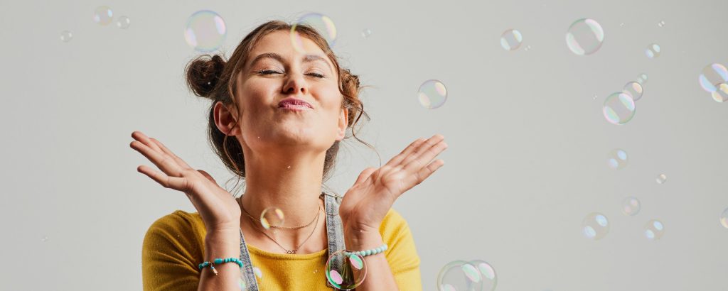 Woman with eyes shut, surrounded by bubbles