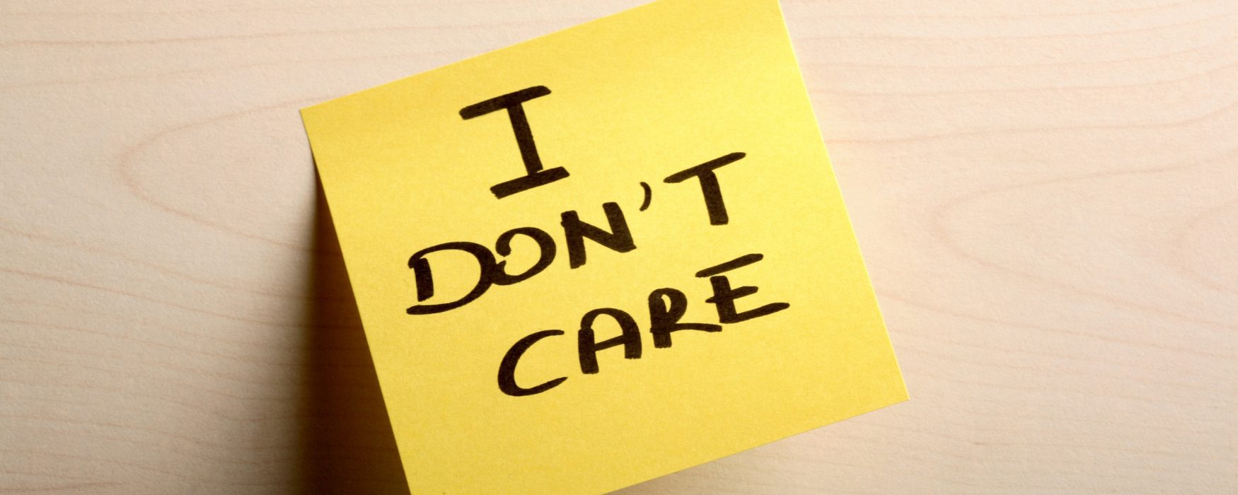 Post-it note with the words "I don't care" written on it.