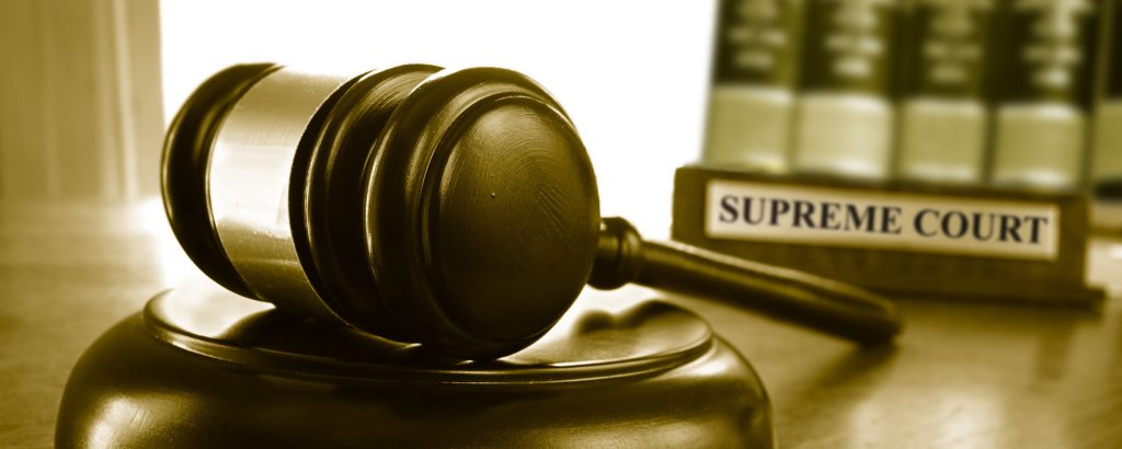 Gavel in front of a sign that says "Supreme Court"