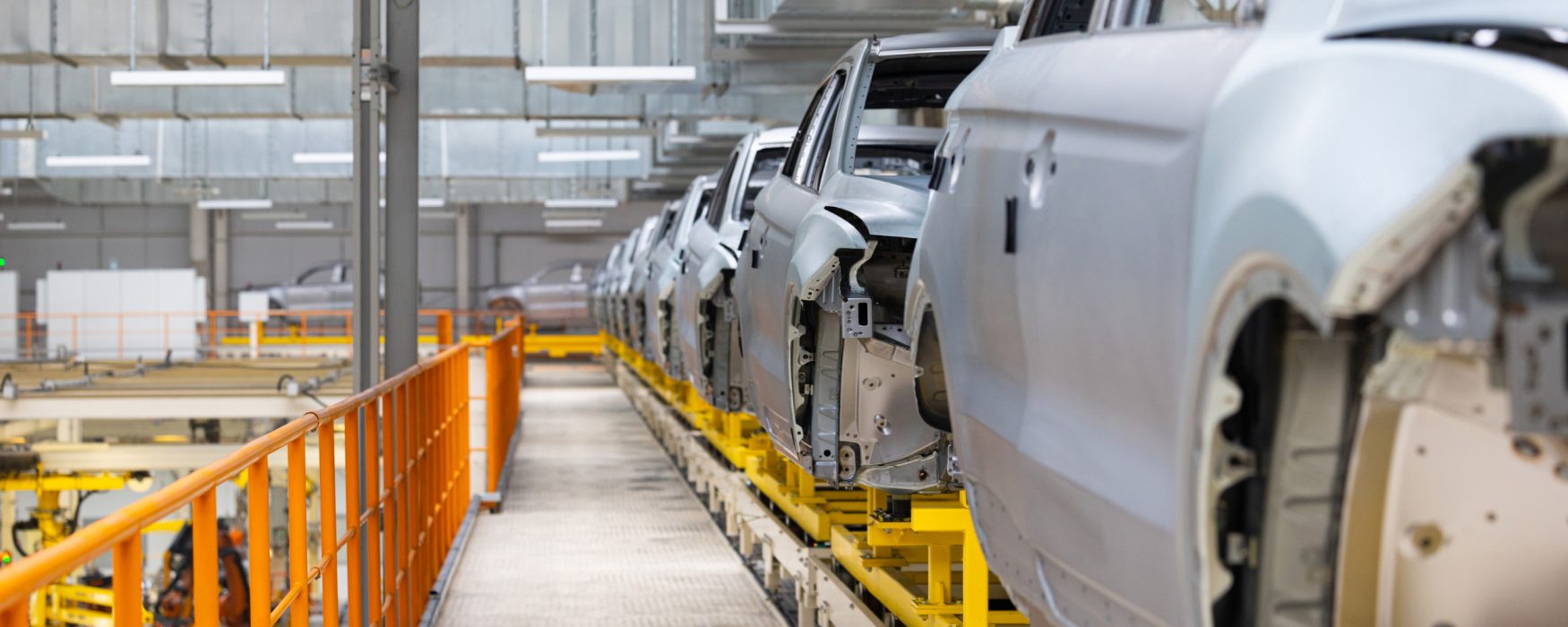 Image of automobiles moving through an assembly line