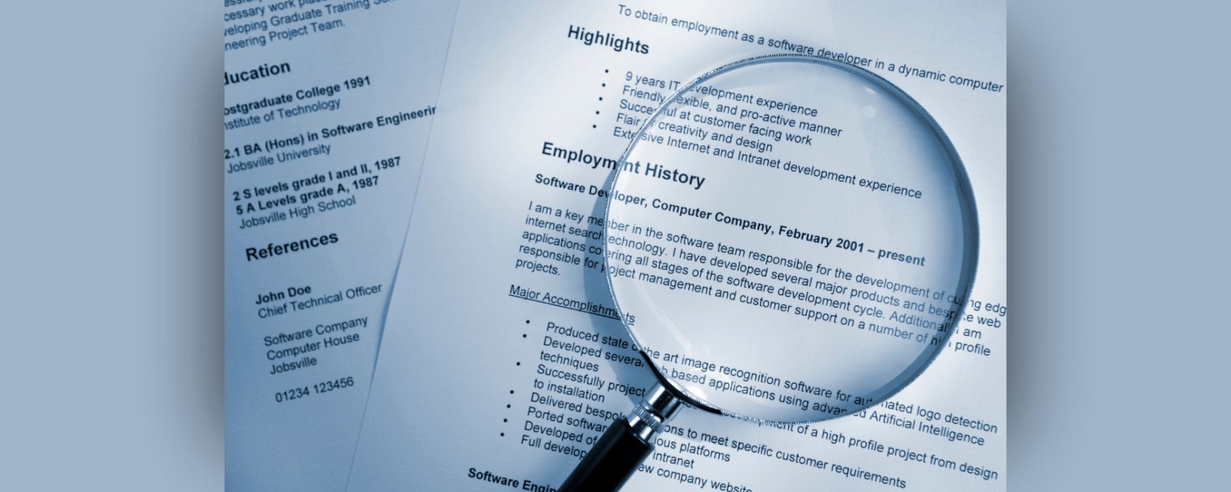 Magnifying glass set on a resume.