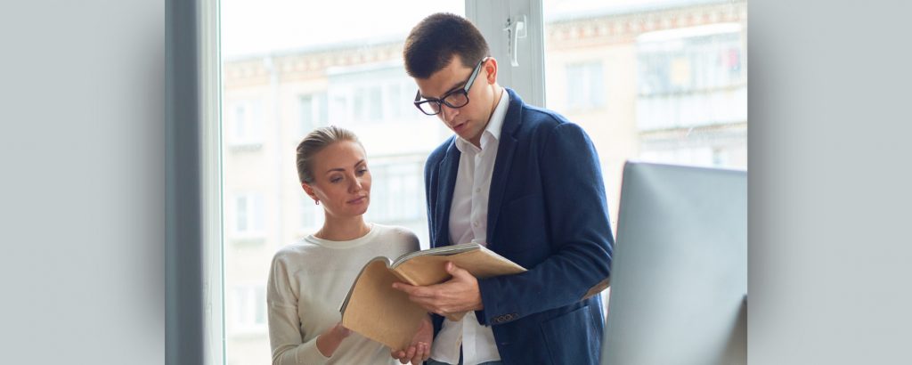 Image of two employees reviewing their employee handbook
