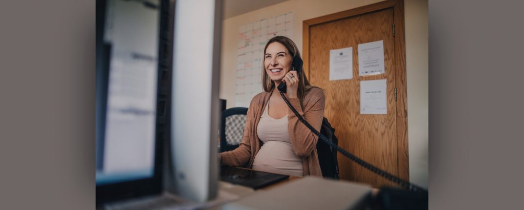 Pregnant woman on a phone in an office setting