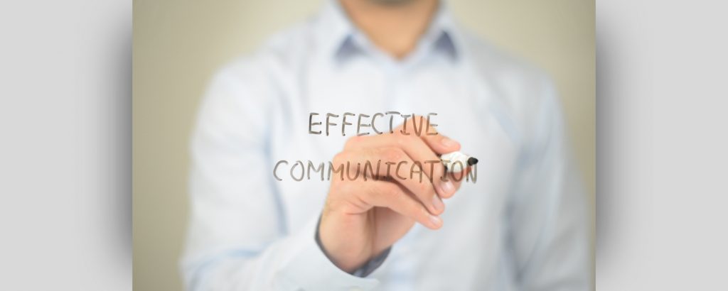 Image of a person writing the words 'effective communication'