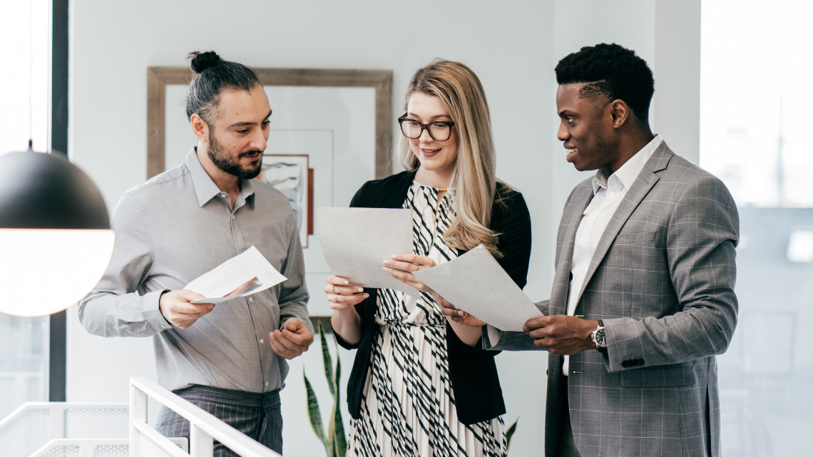 Image of three people in a workplace; human capital