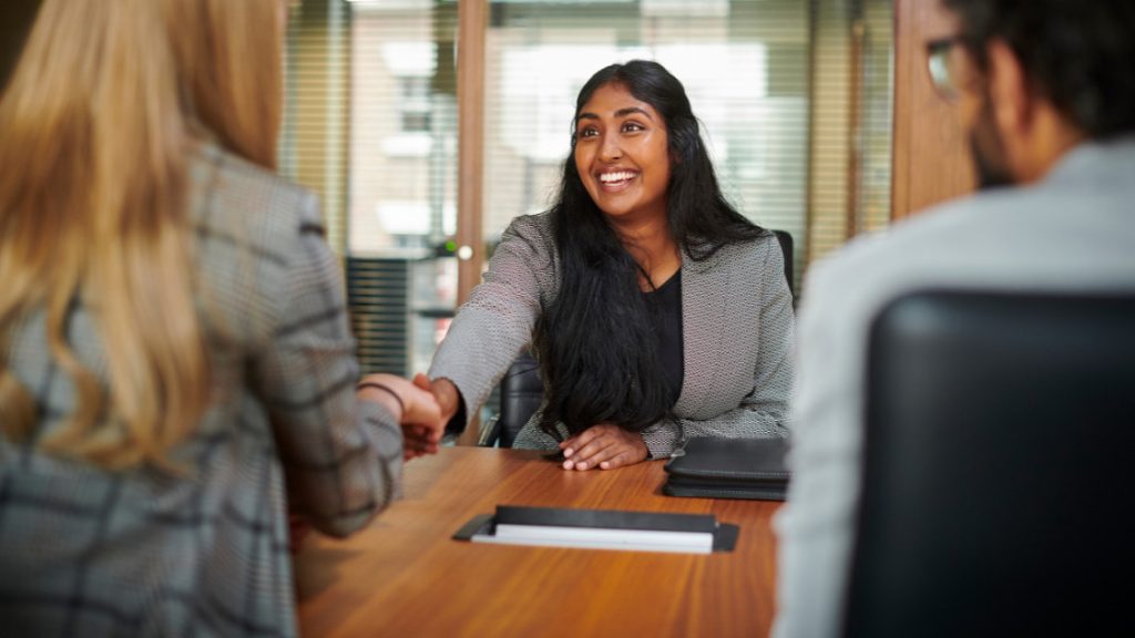Person shaking hands with interviewer during job interview