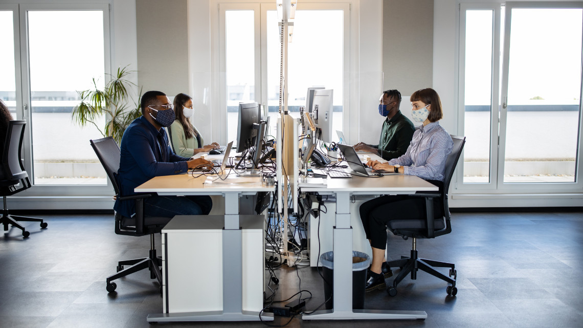 Image illustrating return to work with a group of employees working together at a table