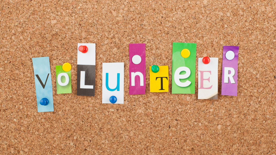 A bulletin board with the word volunteer spelled out using colorful letters