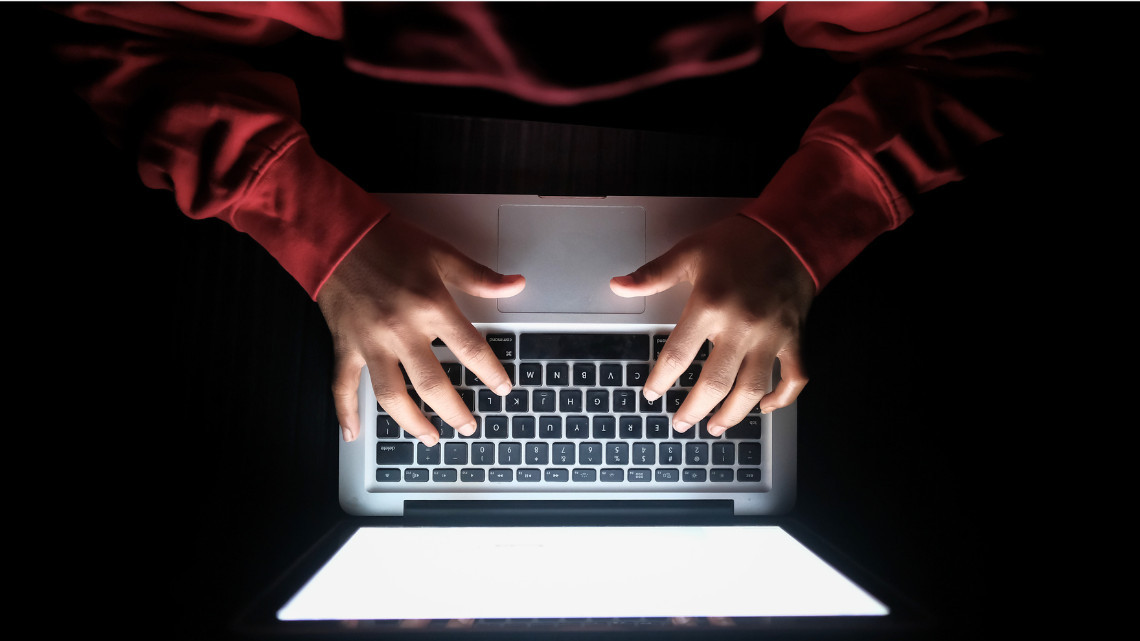 cybercriminal working at a laptop