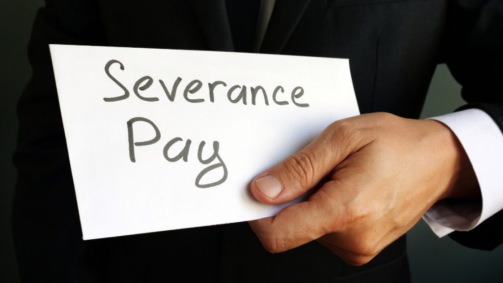 person holding an envelope marked with the words 'severence pay'