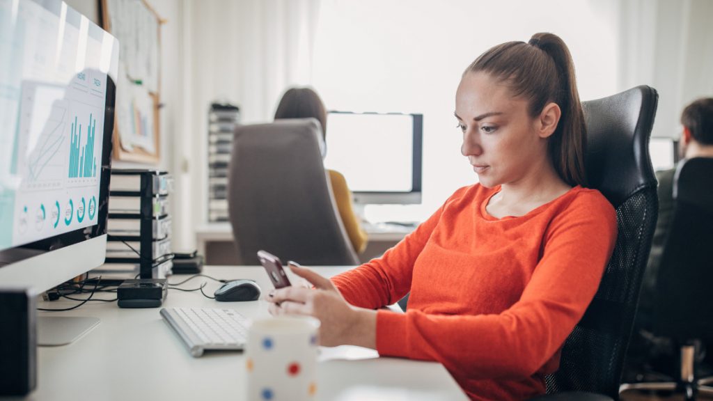 Millennial on phone during work.